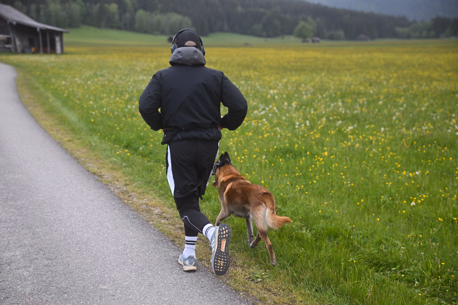 Aaron Schwägerl beim Laufen auf einem Wiesenweg, sein Hund läuft neben ihm